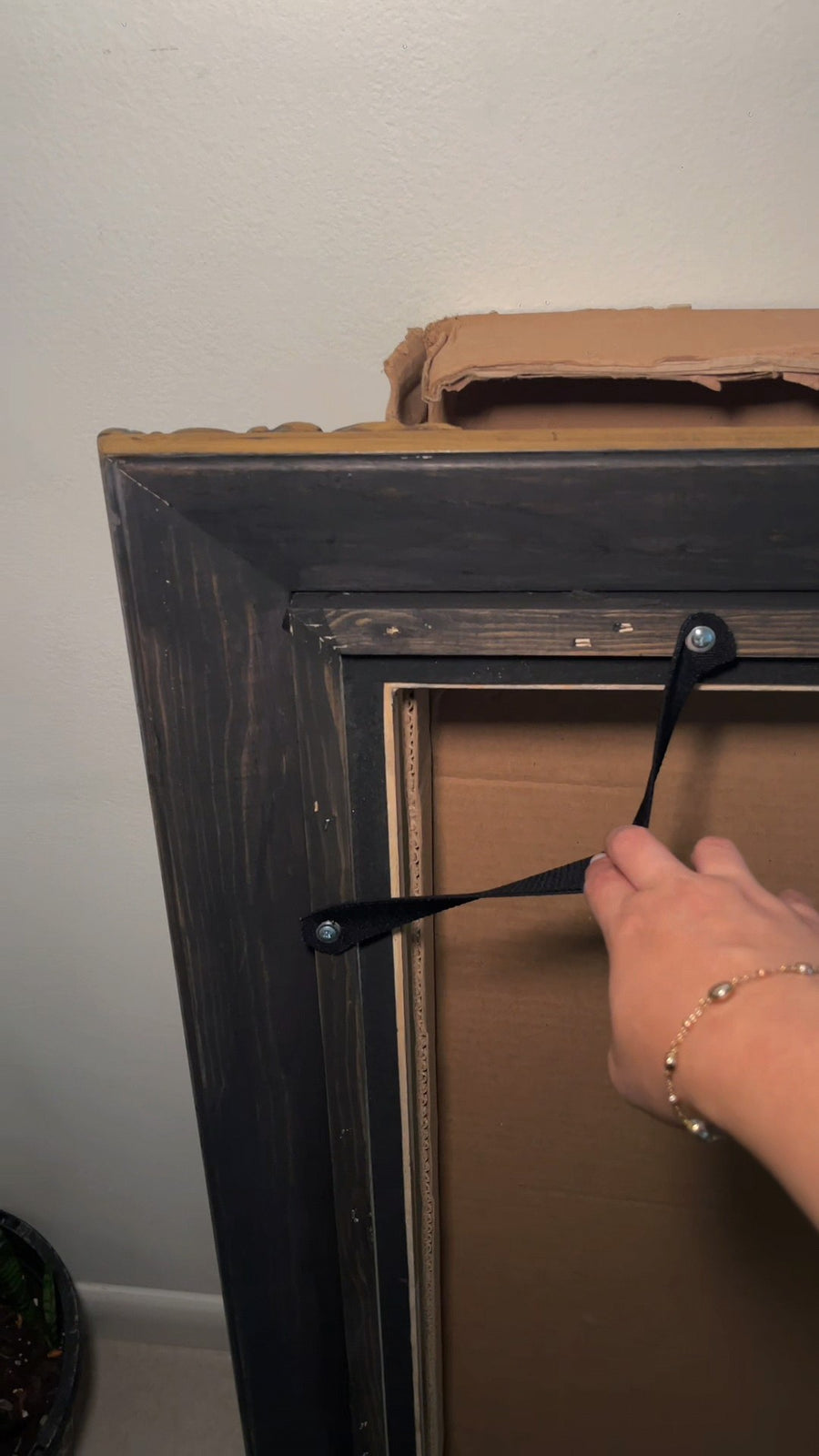 The preinstalled attachment straps on the back of a TV frame